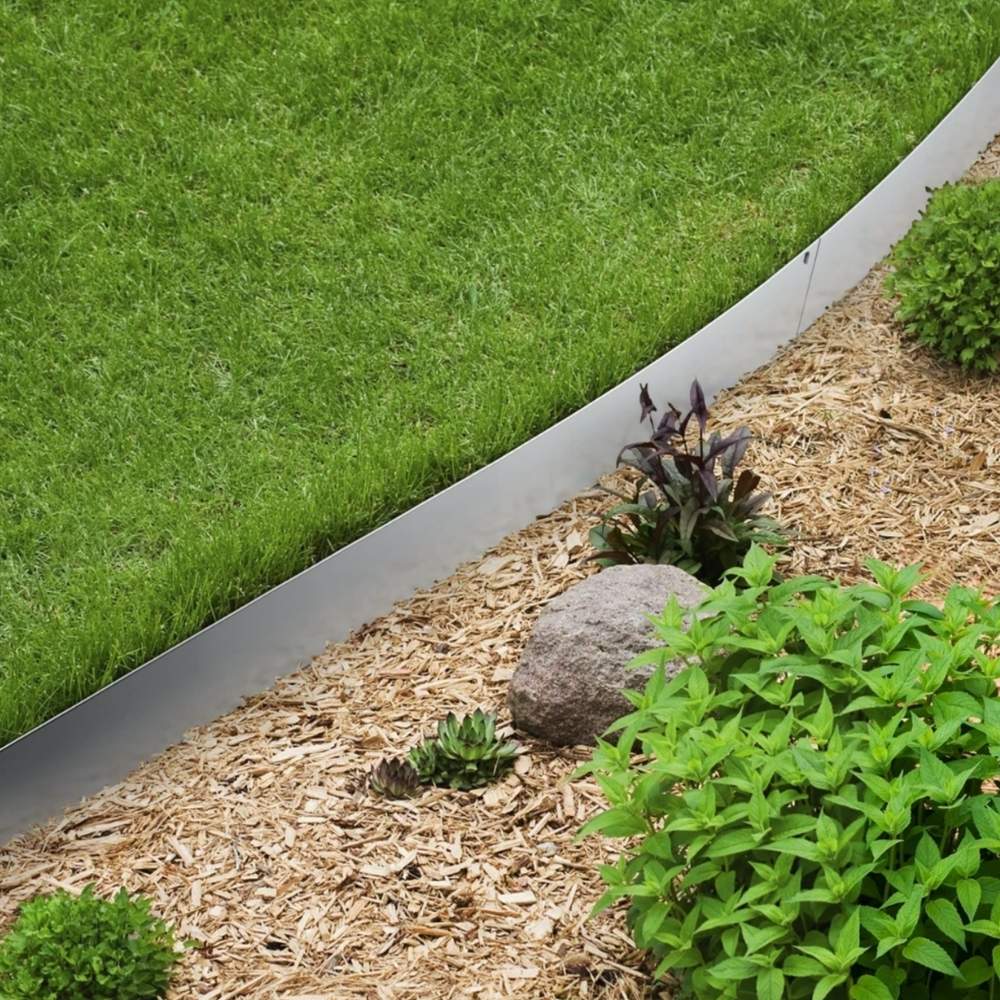 Stainless steel edging curving between a lawn and a mulched bed
